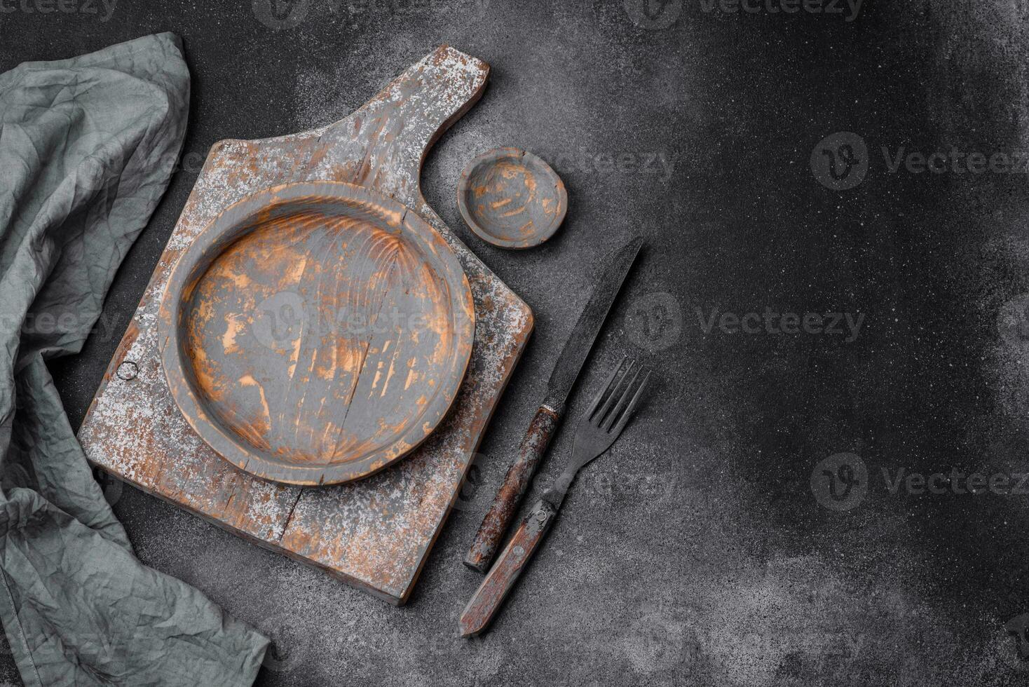 Empty wooden plate, knife, fork and cutting board photo