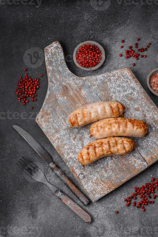 Delicious grilled sausages from chicken or pork meat with salt, spices and herbs photo