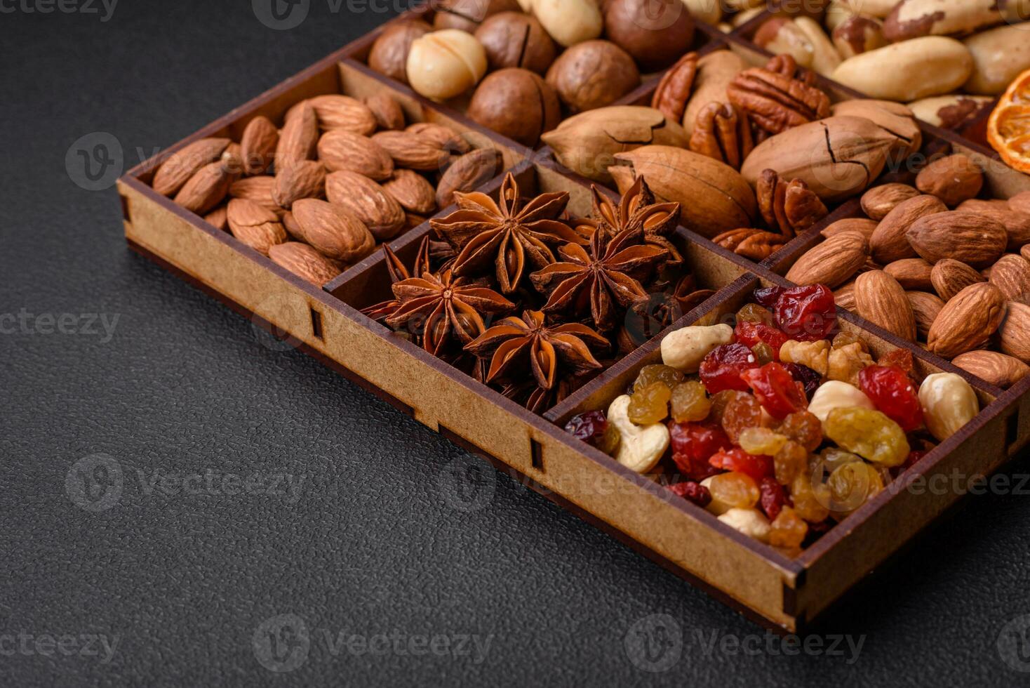 Mix of roasted macadamia nuts, cashews, pecans, almonds, raisins and dry berries photo
