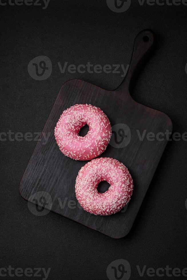 Delicious fresh sweet donuts in pink glaze with strawberry filling photo