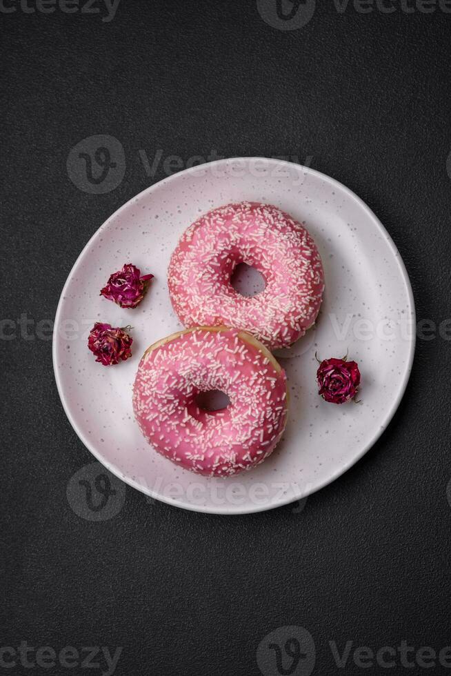 Delicious fresh sweet donuts in pink glaze with strawberry filling photo