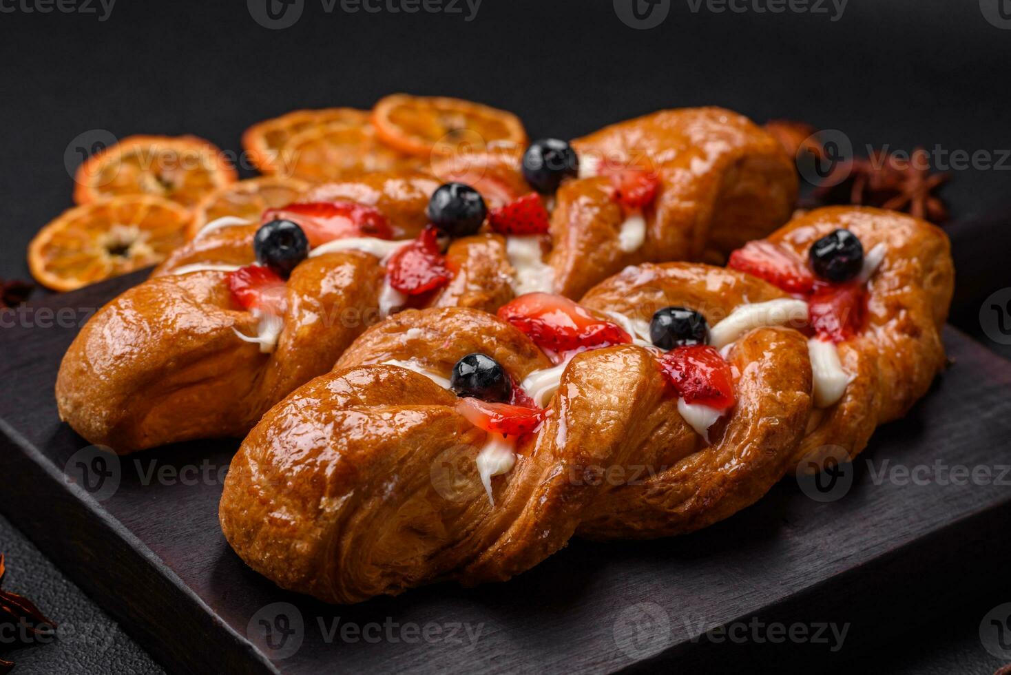 Delicious fresh crispy pastry in the form of a pigtail with strawberries and blueberries photo
