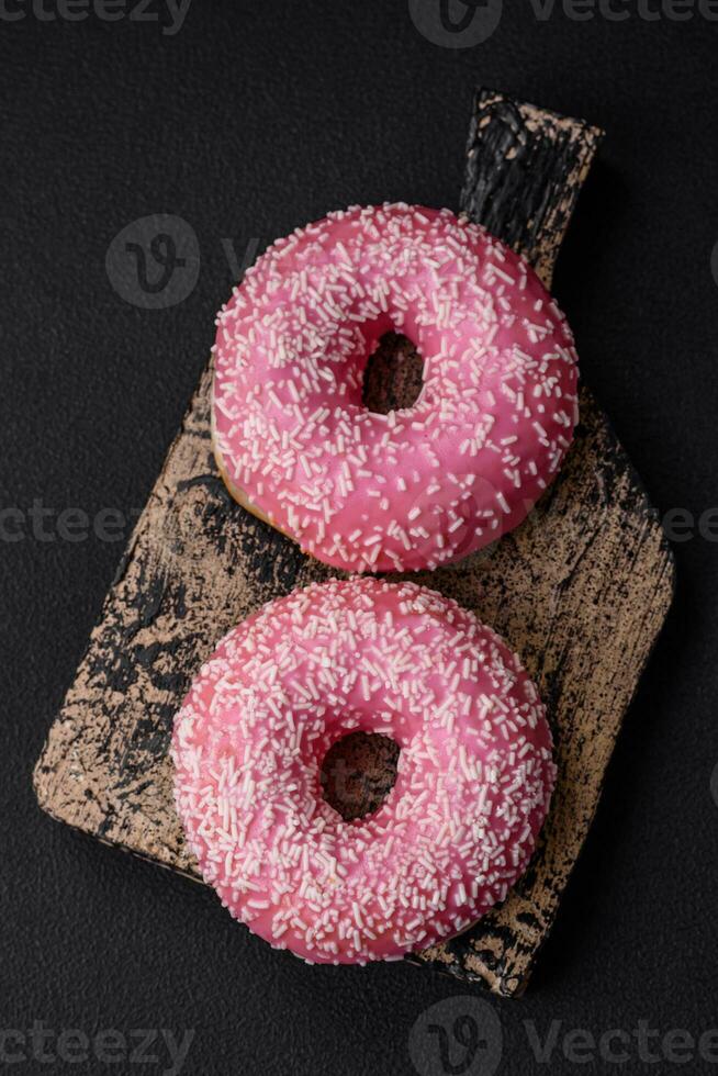 Delicious fresh sweet donuts in pink glaze with strawberry filling photo