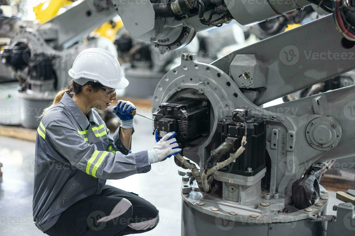 Robotic technicians tighten and loosen components with screwdriver and plier to perform safety maintenance. Measuring current, voltage, resistance, capacity, temperature with digital clamp meter. photo
