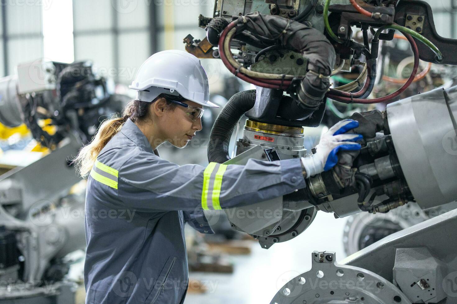 Robotic technicians tighten and loosen components with screwdriver and plier to perform safety maintenance. Measuring current, voltage, resistance, capacity, temperature with digital clamp meter. photo