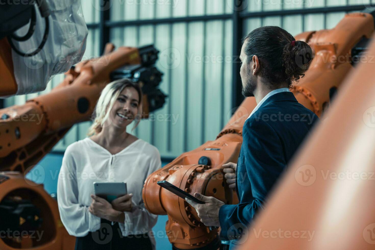 Robotic factory owner explain, discuss functionality and performance of robot systems with client. Answering questions about after-sales service. Price negotiation. Developing long-term relationships photo
