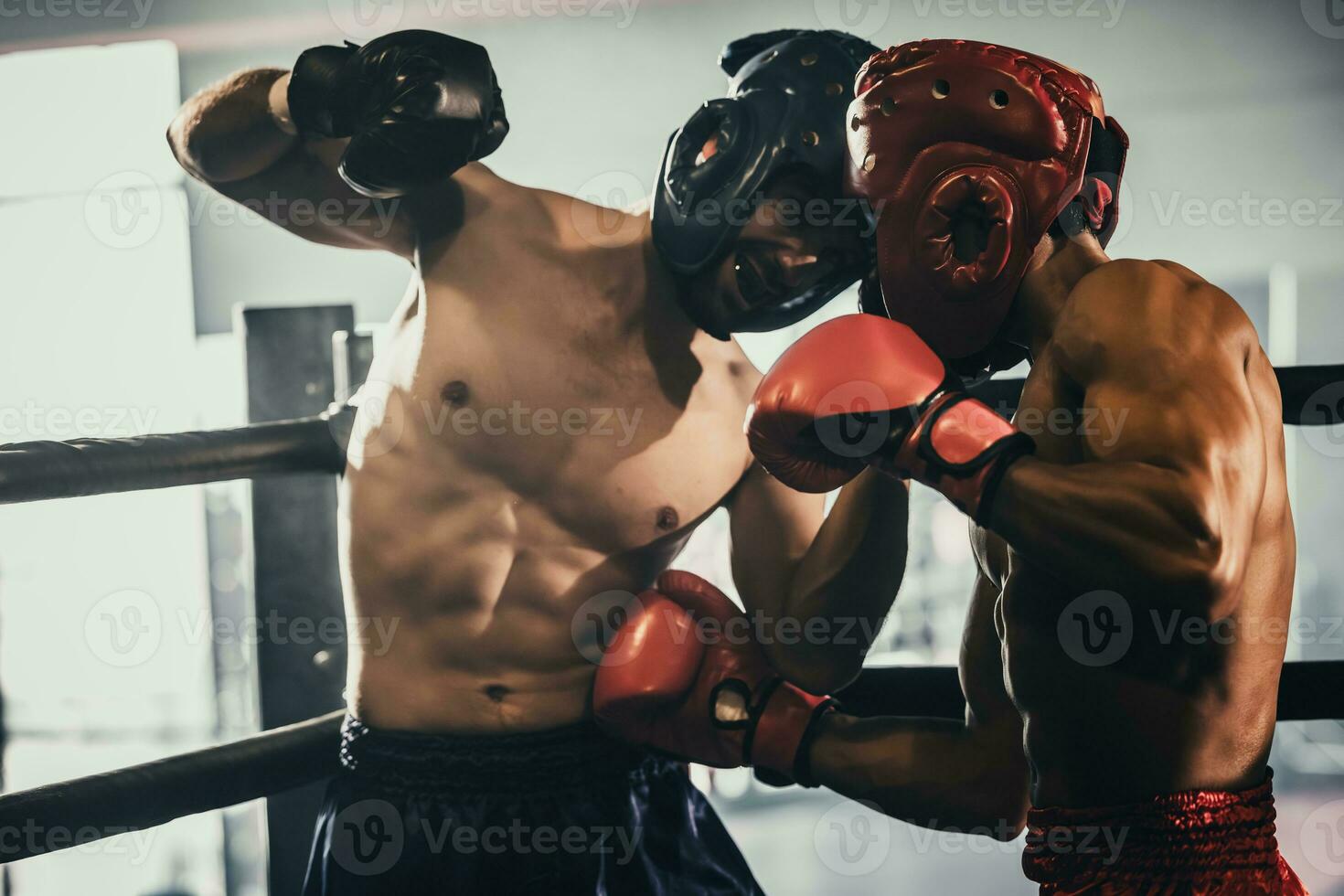 Boxer use various punch combinations, including the jab, hook, uppercut, cross, swing, straight. Getting in close to make opponent on ropes and knockout. Boxing champions win the round in boxing ring photo