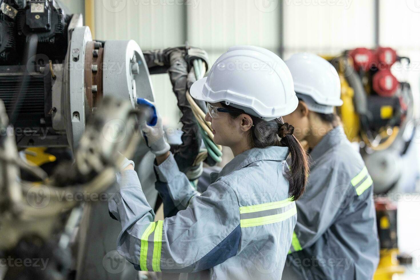 Robotic technicians tighten and loosen components with screwdriver and plier to perform safety maintenance. Measuring current, voltage, resistance, capacity, temperature with digital clamp meter. photo