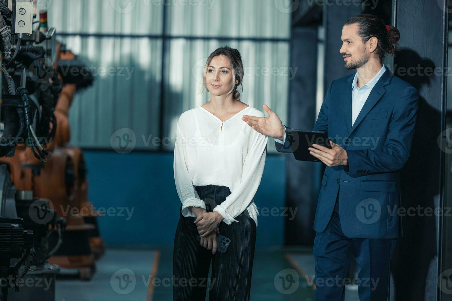 Robotic factory owner explain, discuss functionality and performance of robot systems with client. Answering questions about after-sales service. Price negotiation. Developing long-term relationships photo