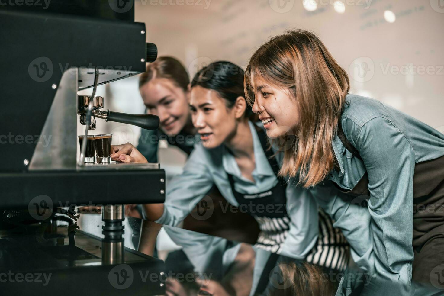 Young adult coffee makers work with skilled baristas to create menus. Using a coffee machine to make hot and cold coffee. Experiment with grinding and blending, including adding milk foam on top. photo