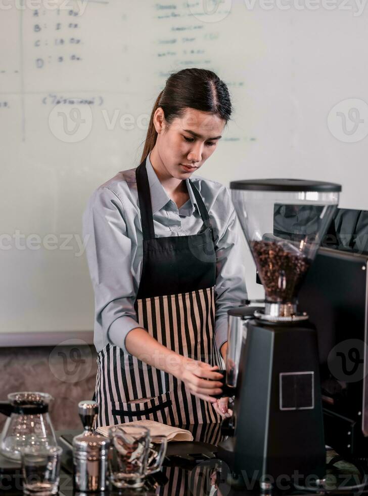 Young adult coffee makers work with skilled baristas to create menus. Using a coffee machine to make hot and cold coffee. Experiment with grinding and blending, including adding milk foam on top. photo