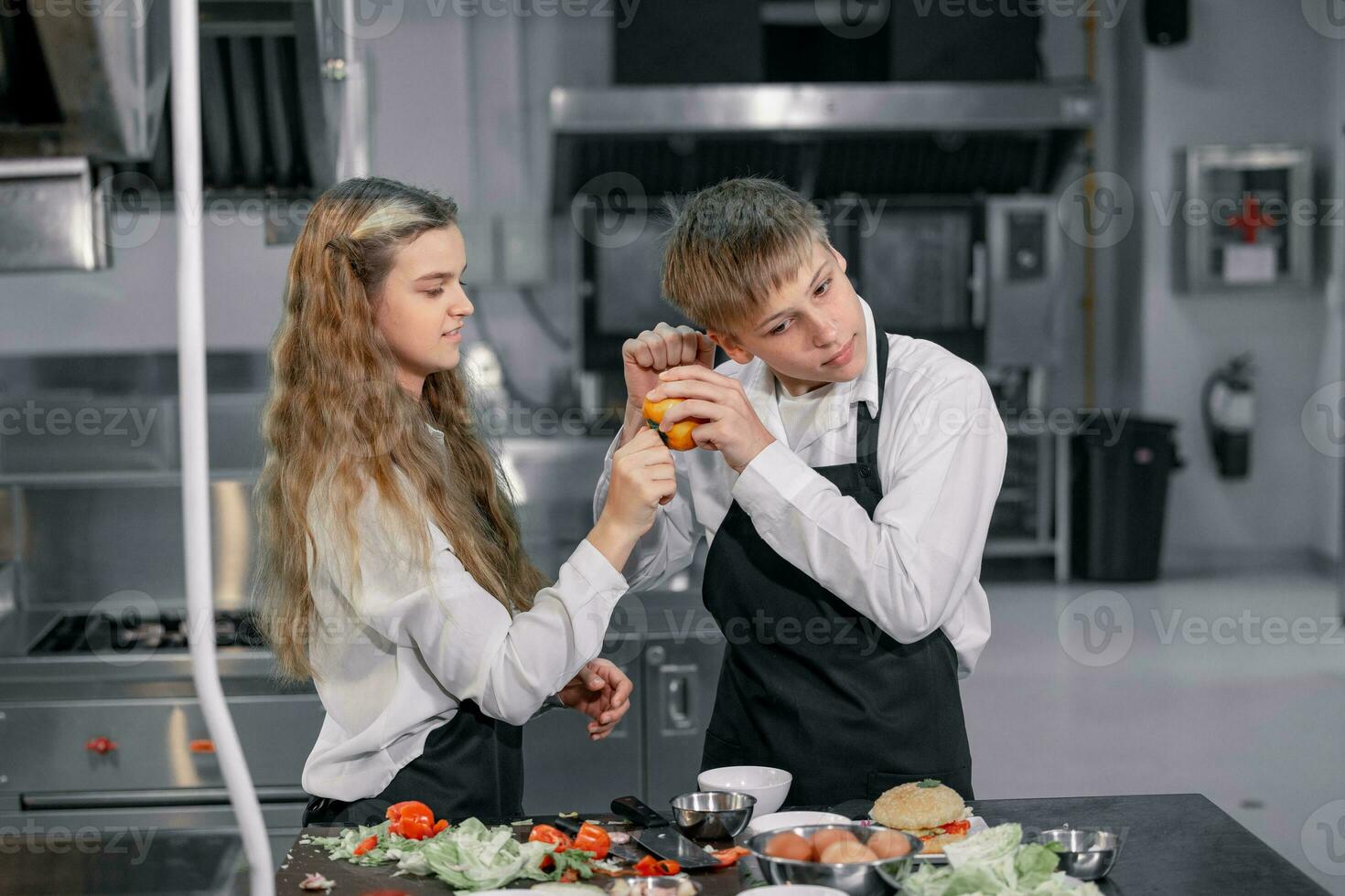 Teenagers learn from expert chefs at culinary school to prepare ingredients and create a variety of tasty meals. A practical activity connected their senses of taste and smell is making hamburgers. photo