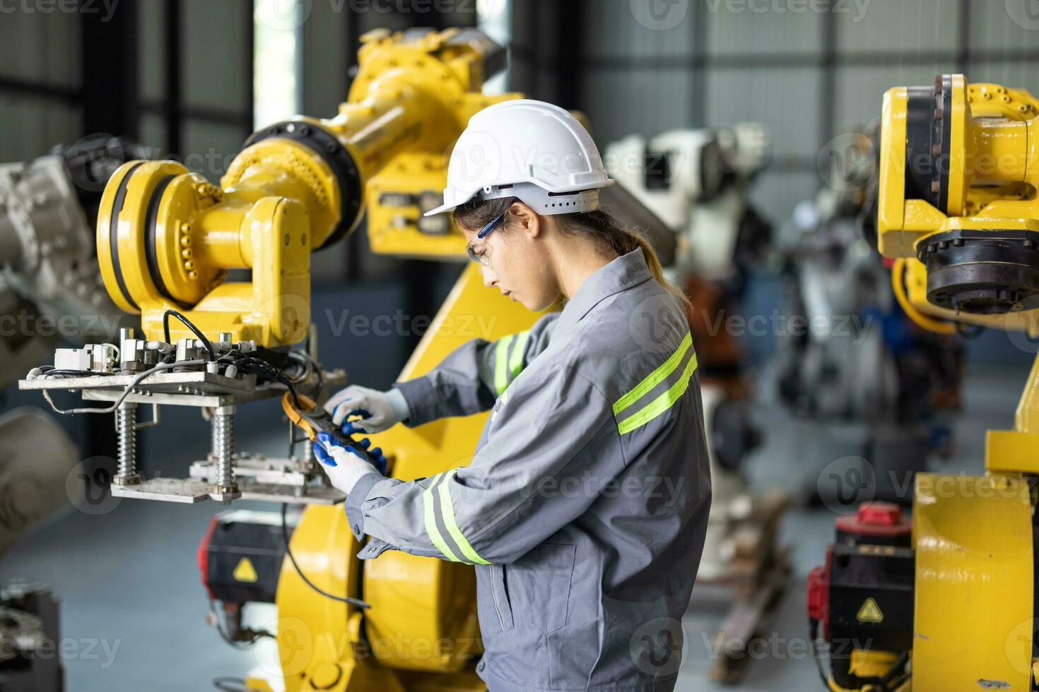 Robotic technicians tighten and loosen components with screwdriver and plier to perform safety maintenance. Measuring current, voltage, resistance, capacity, temperature with digital clamp meter. photo