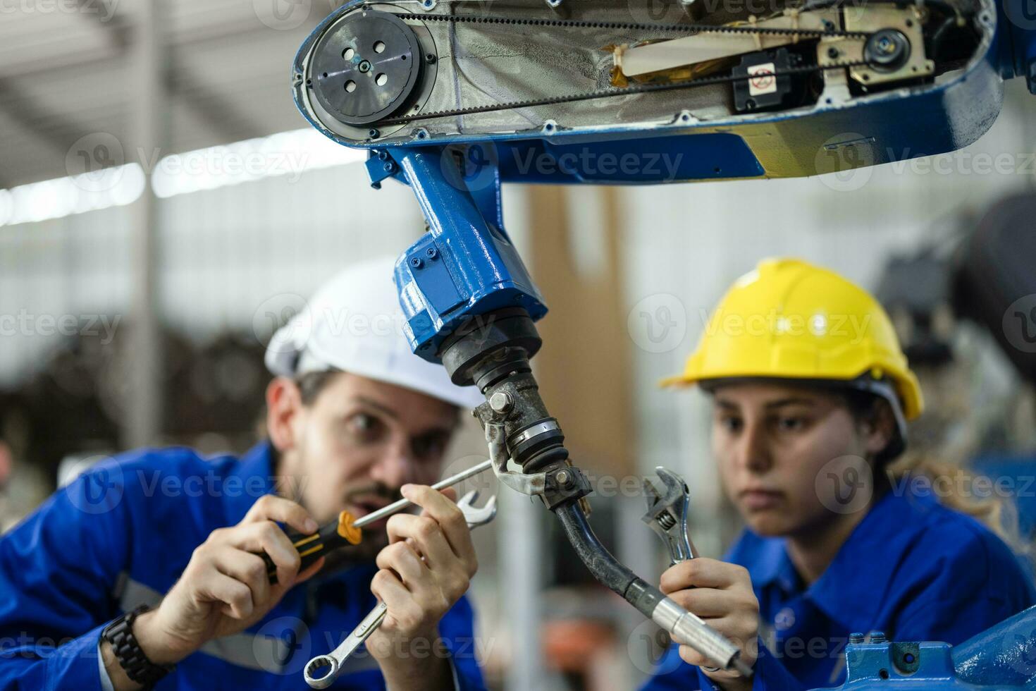 Robotic technicians tighten and loosen components with screwdriver and plier to perform safety maintenance. Measuring current, voltage, resistance, capacity, temperature with digital clamp meter. photo