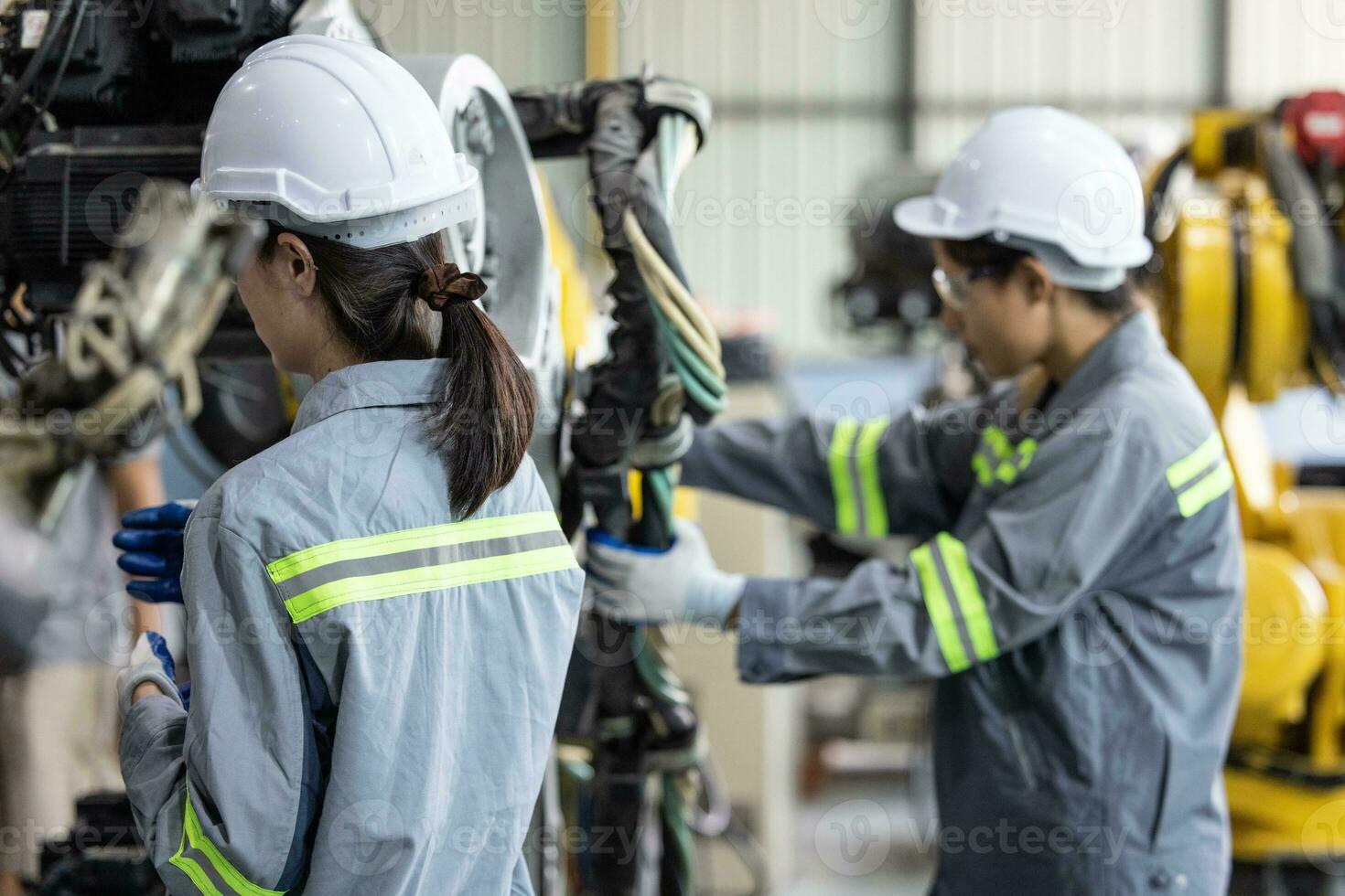 Robotic technicians tighten and loosen components with screwdriver and plier to perform safety maintenance. Measuring current, voltage, resistance, capacity, temperature with digital clamp meter. photo