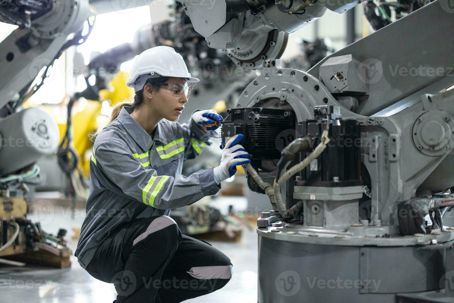Robotic technicians tighten and loosen components with screwdriver and plier to perform safety maintenance. Measuring current, voltage, resistance, capacity, temperature with digital clamp meter. photo