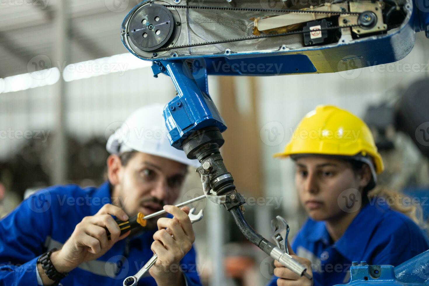 Robotic technicians tighten and loosen components with screwdriver and plier to perform safety maintenance. Measuring current, voltage, resistance, capacity, temperature with digital clamp meter. photo