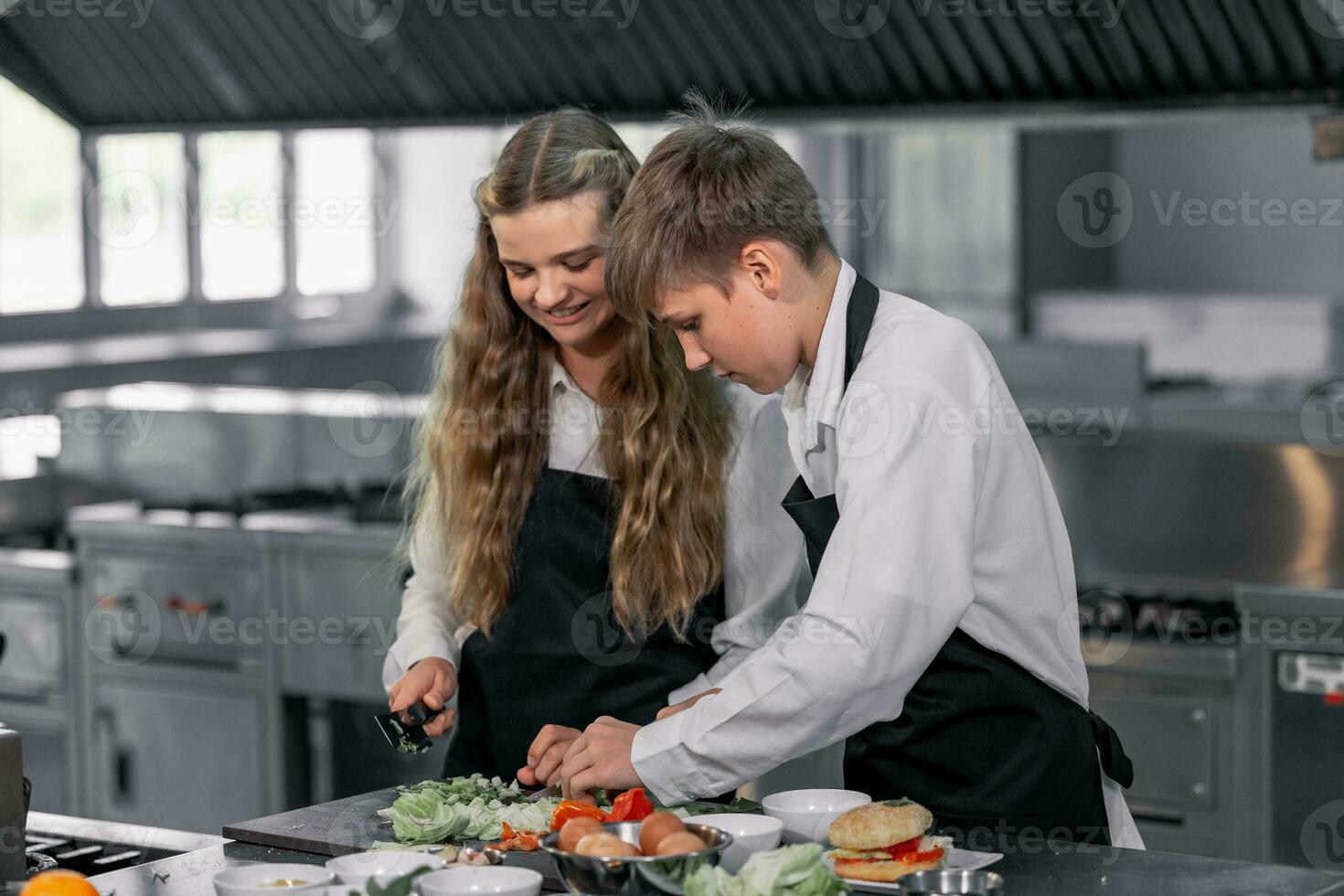 Teenagers learn from expert chefs at culinary school to prepare ingredients and create a variety of tasty meals. A practical activity connected their senses of taste and smell is making hamburgers. photo