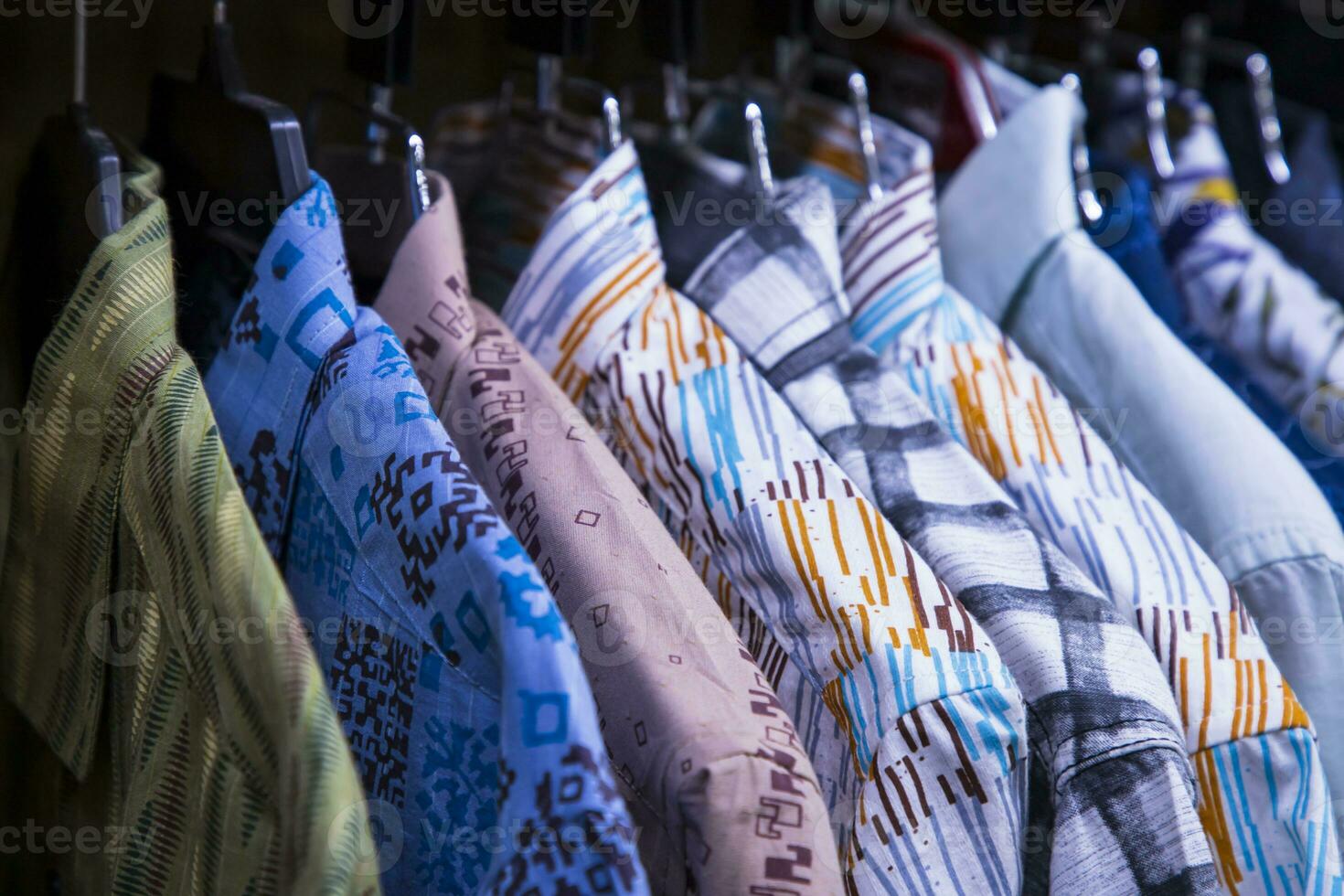 vistoso variedad de camisas tapices en un ropa sala de exposición. grupo atención foto