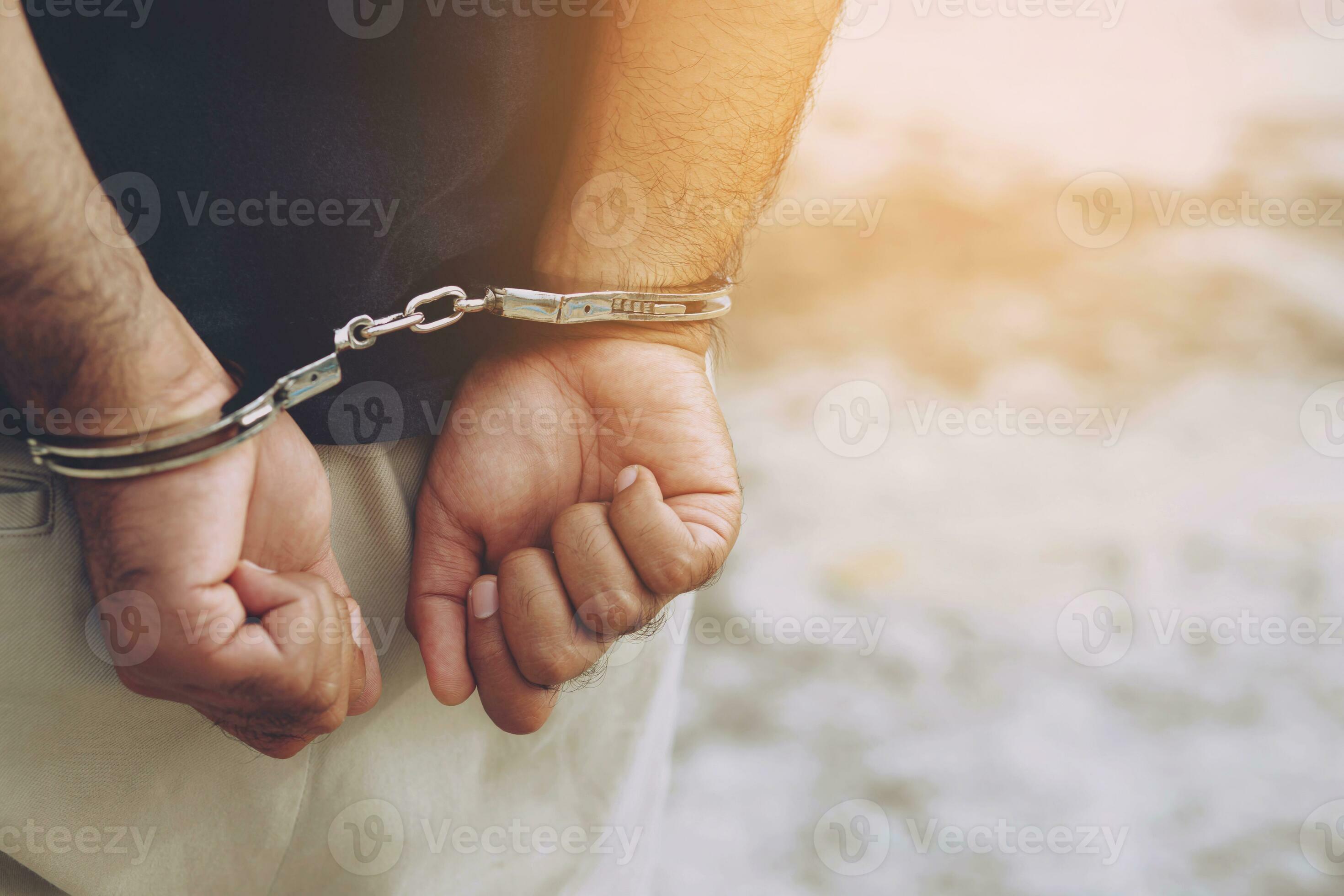 Prisoner male criminal standing in handcuffs with hands behind back