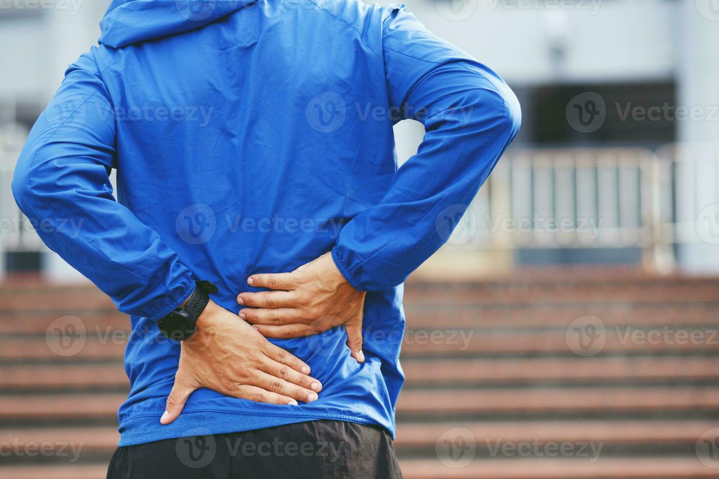 unhappy man suffering from Sport injury while exercise, with Lower back pain in the spine with back ache. people ,health care or medical and lifestyle concept. photo