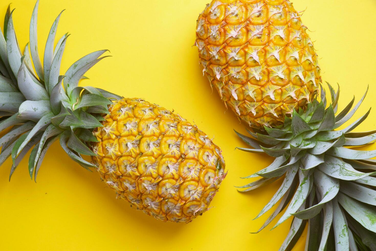 pineapple wearing sunglasses on a yellow background photo