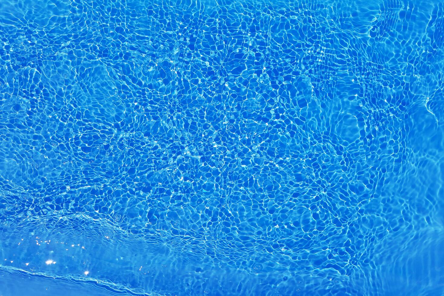 azul agua con ondas en el superficie. desenfocar borroso transparente azul de colores claro calma agua superficie textura con salpicaduras y burbujas agua olas con brillante modelo textura antecedentes. foto