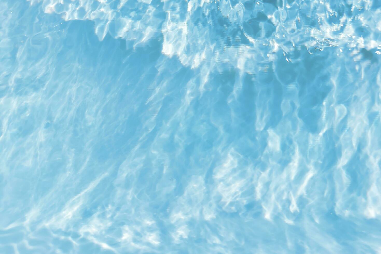 Blue water with ripples on the surface. Defocus blurred transparent blue colored clear calm water surface texture with splashes and bubbles. Water waves with shining pattern texture background. photo