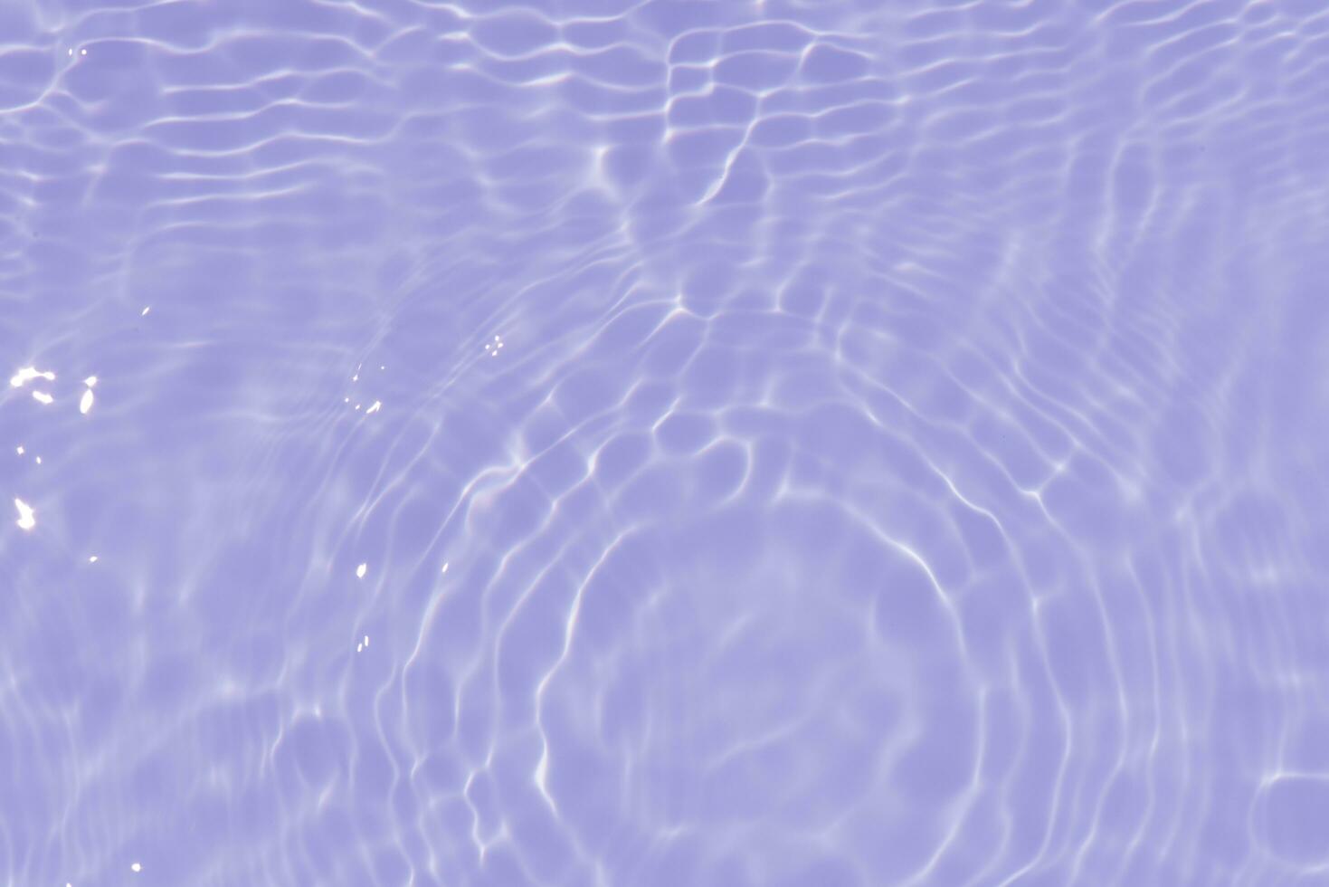 Purple water with ripples on the surface. Defocus blurred transparent pink colored clear calm water surface texture with splashes and bubbles. Water waves with shining pattern texture background. photo