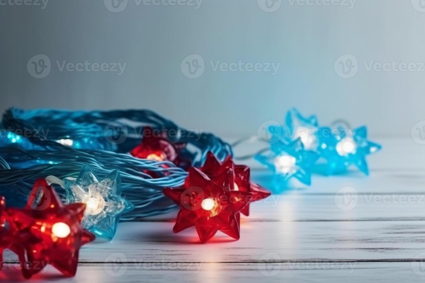 Christmas background with blue light luminous garlands and red stars on a white wooden background with copy space. photo