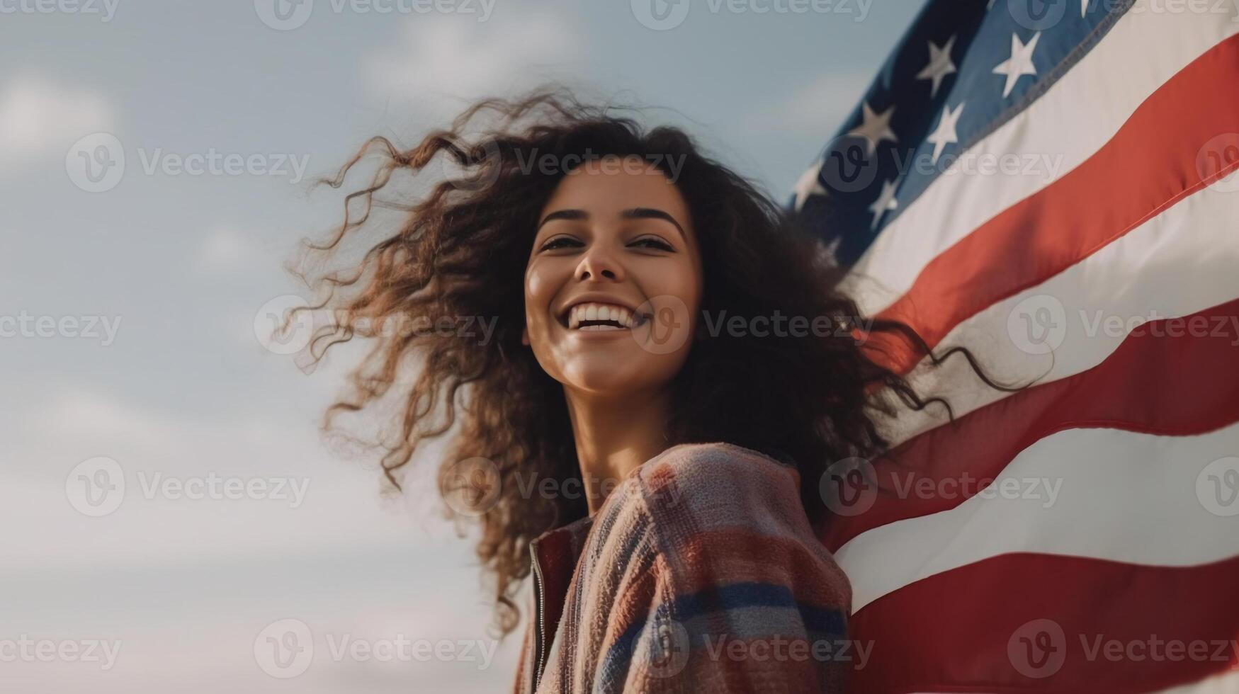 Woman smiling and holding wide waving american flag high in sky. photo