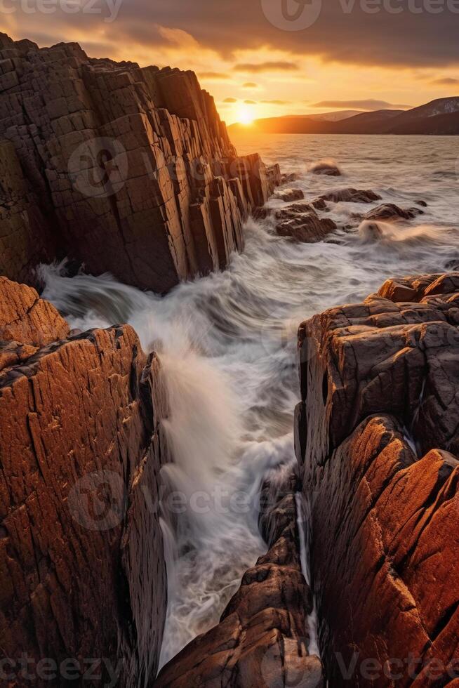 The waves are crashing over the rocks at sunset. photo
