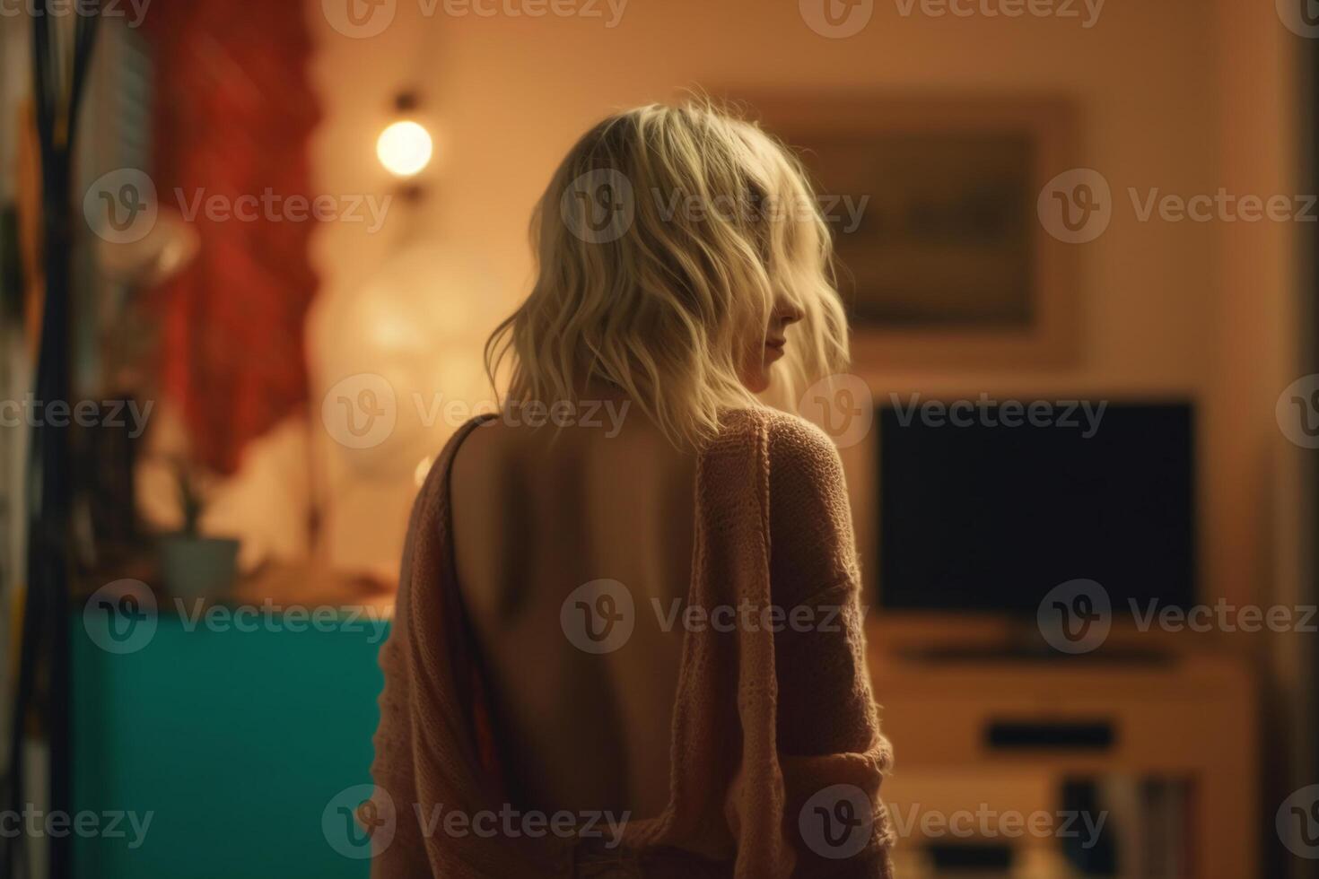 sad blonde woman back view in her room standing. photo