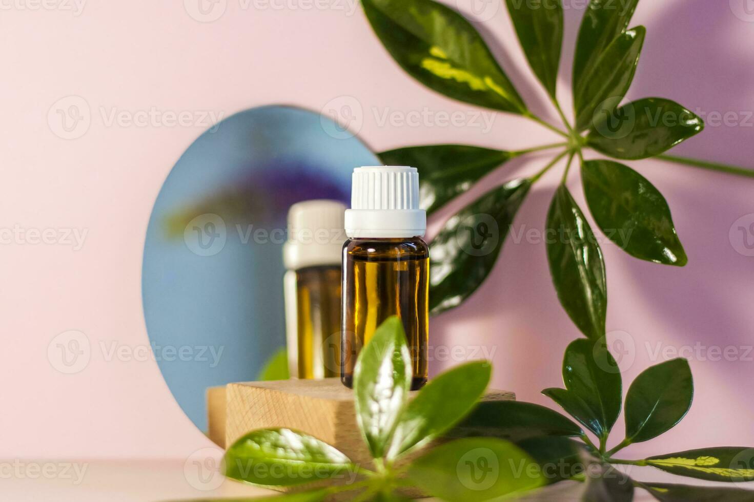 The mirror reflects a brown glass bottle with an eyedropper on a beige-pink background. Organic natural essential oil for aromatherapy. photo