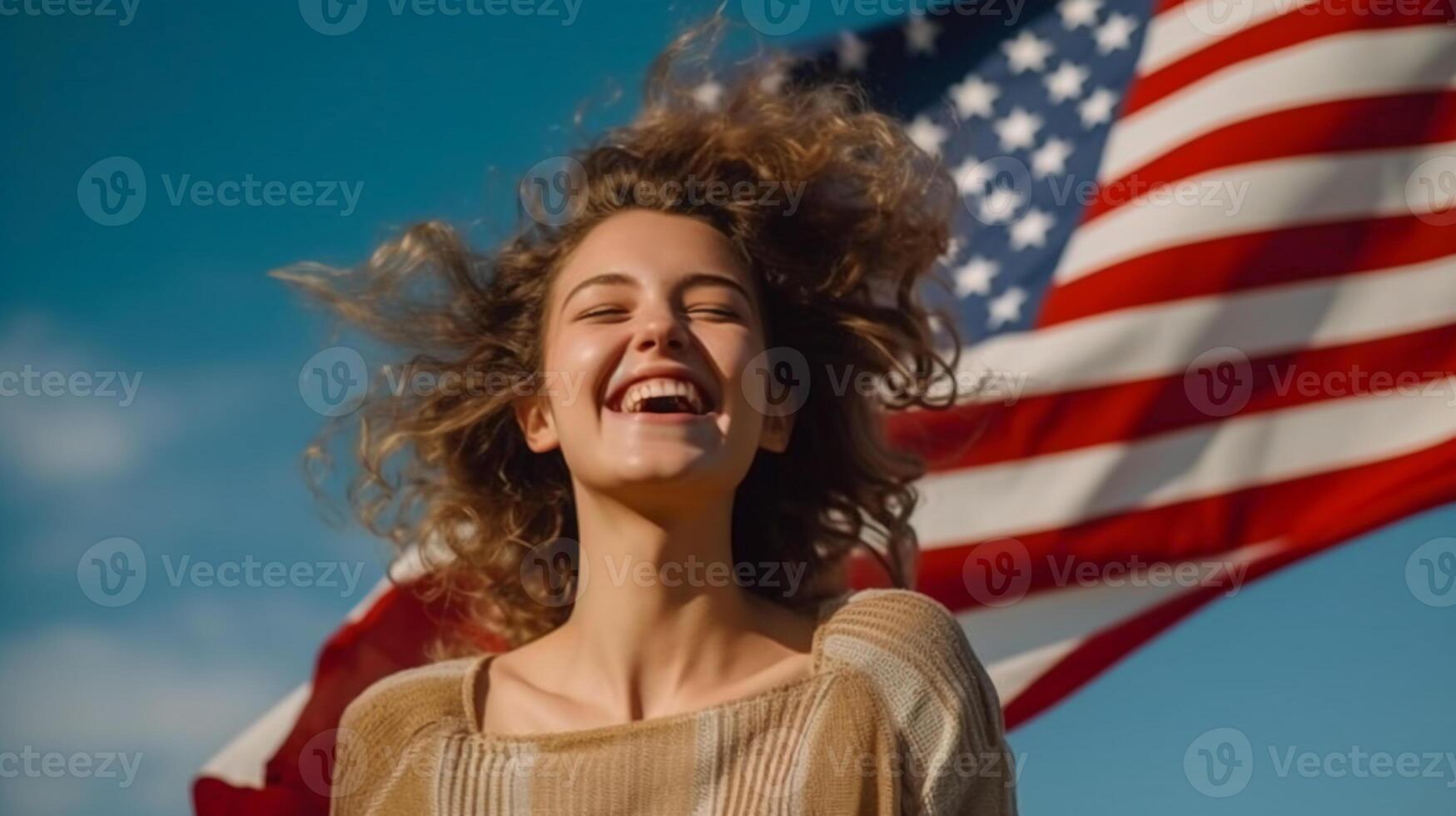 Woman smiling and holding wide waving american flag high in sky. photo