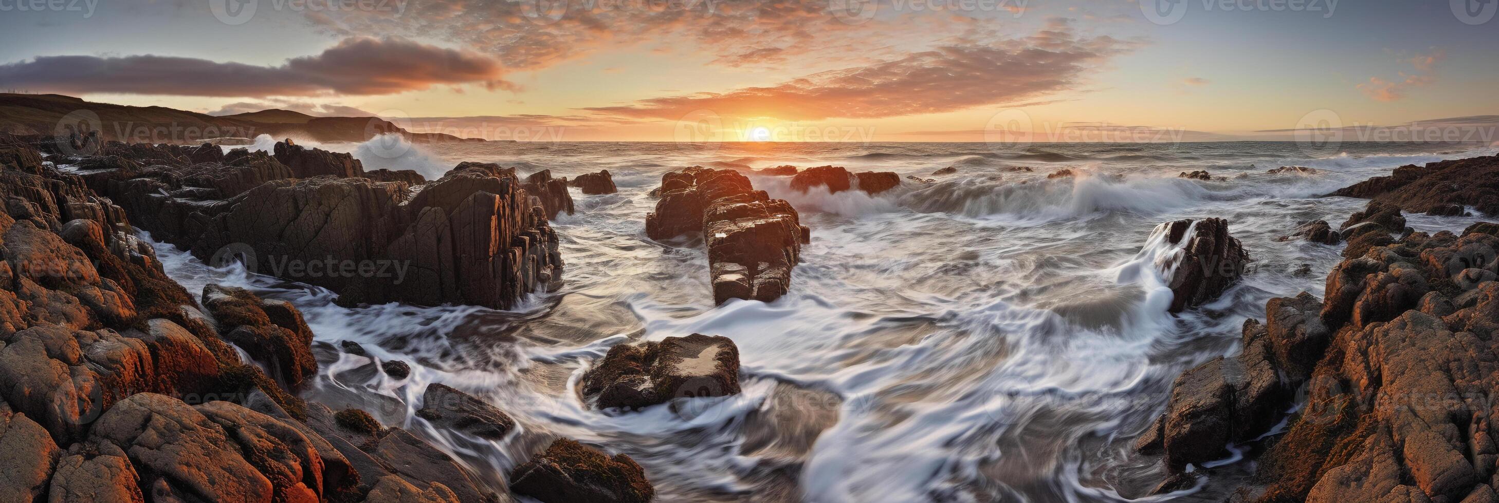 The waves are crashing over the rocks at sunset. photo