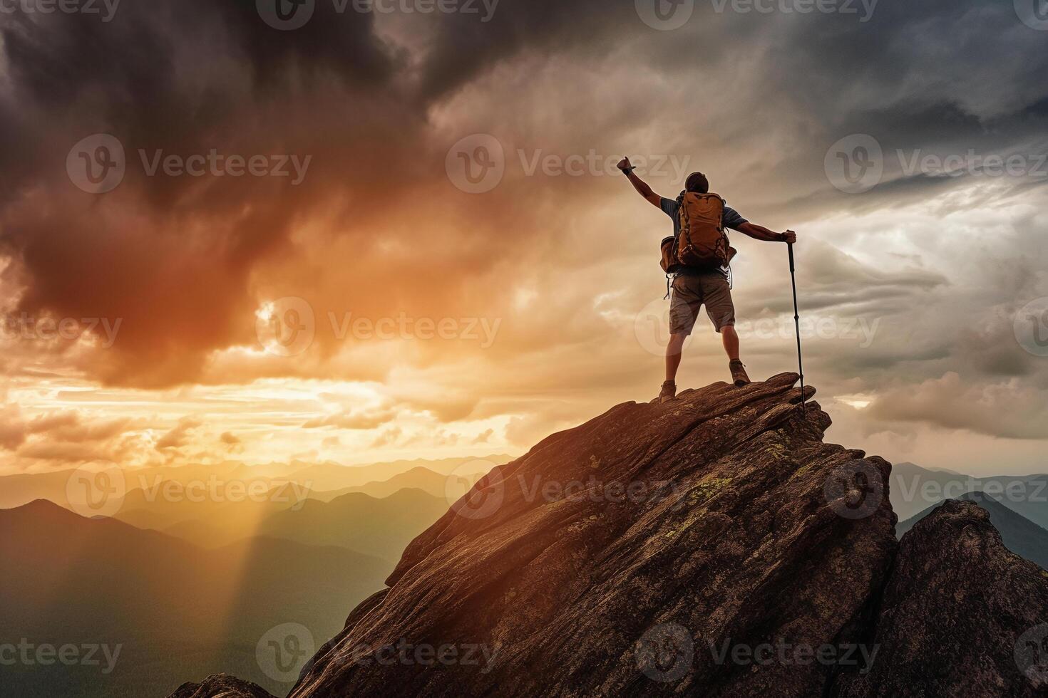 Successful hiker hiking a mountain pointing to the sunset. photo
