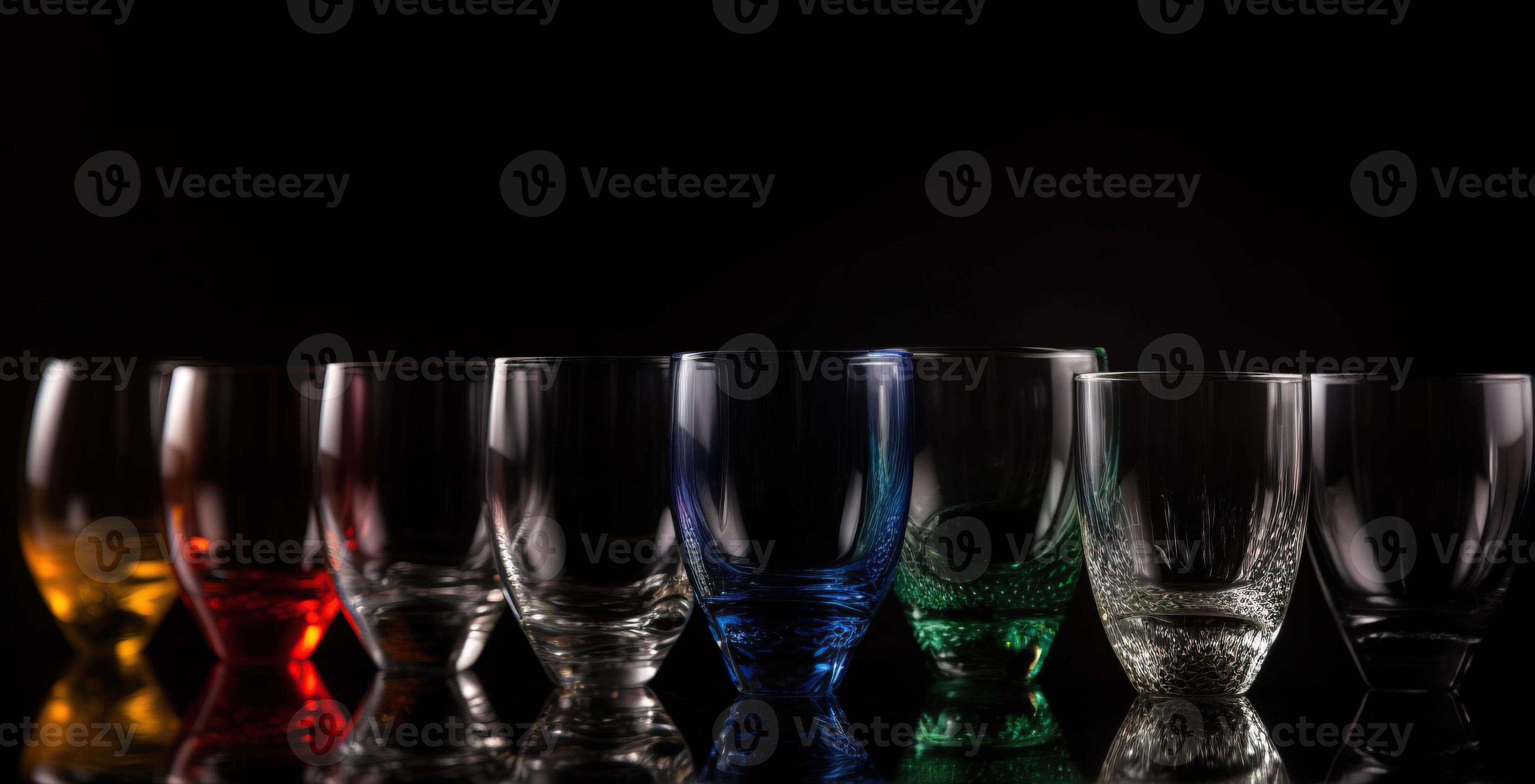 Various colored glasses for different drinks in a row, black background