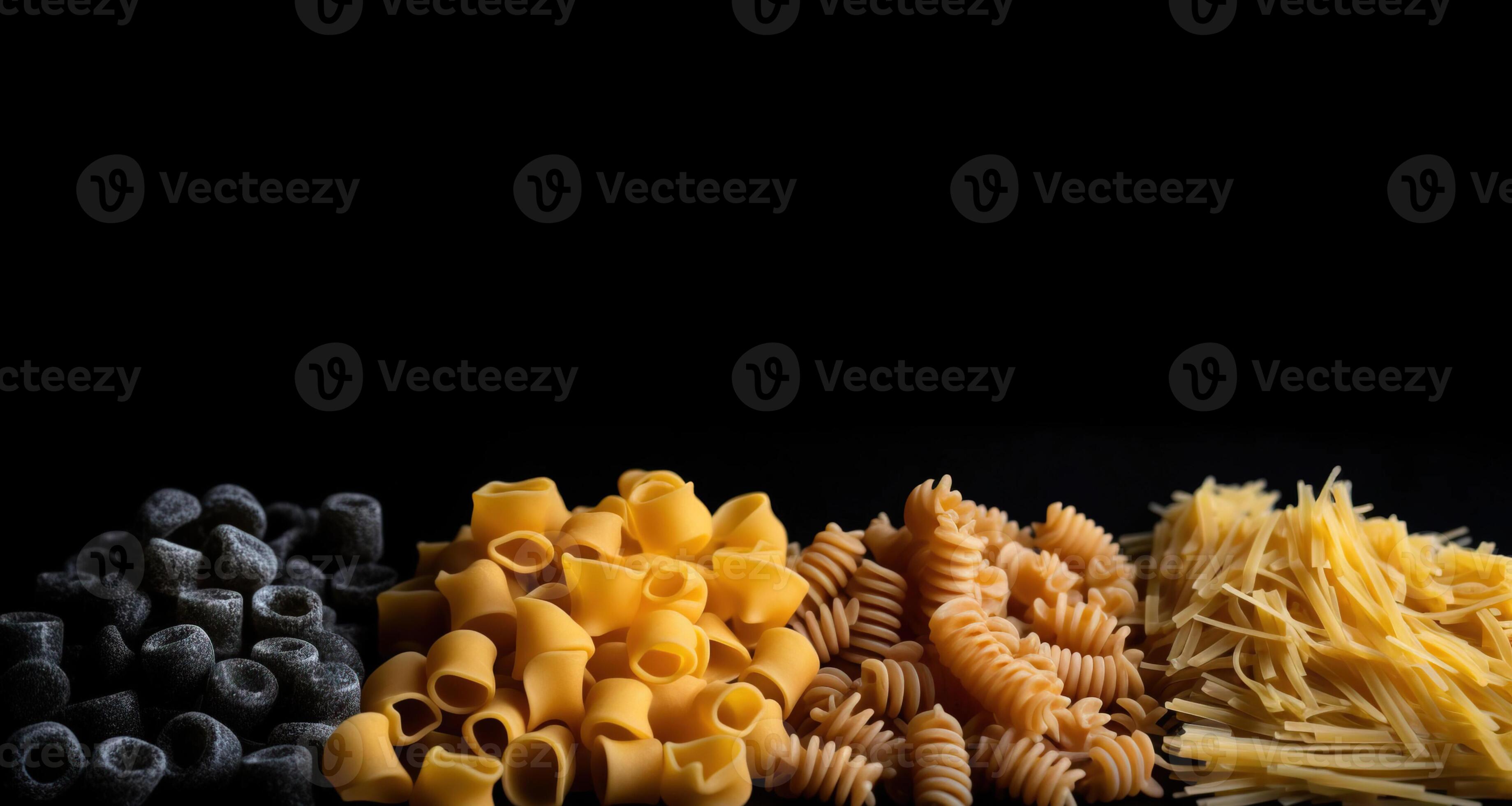 Various groups of raw colored flour wheat pasta in a row, black