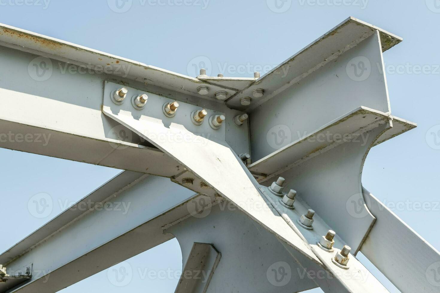 Bolts and nuts on metal plates of steel structure of heavy duty straight crossbar of frame and bridge support photo