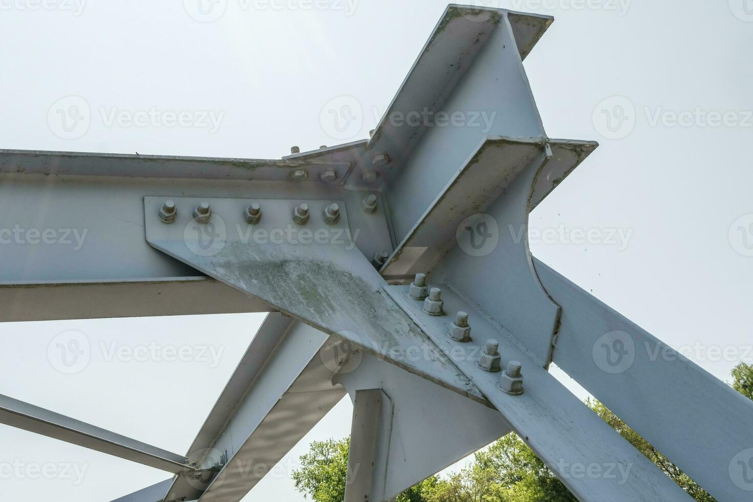 Bolts and nuts on metal plates of steel structure of heavy duty straight crossbar of frame and bridge support photo