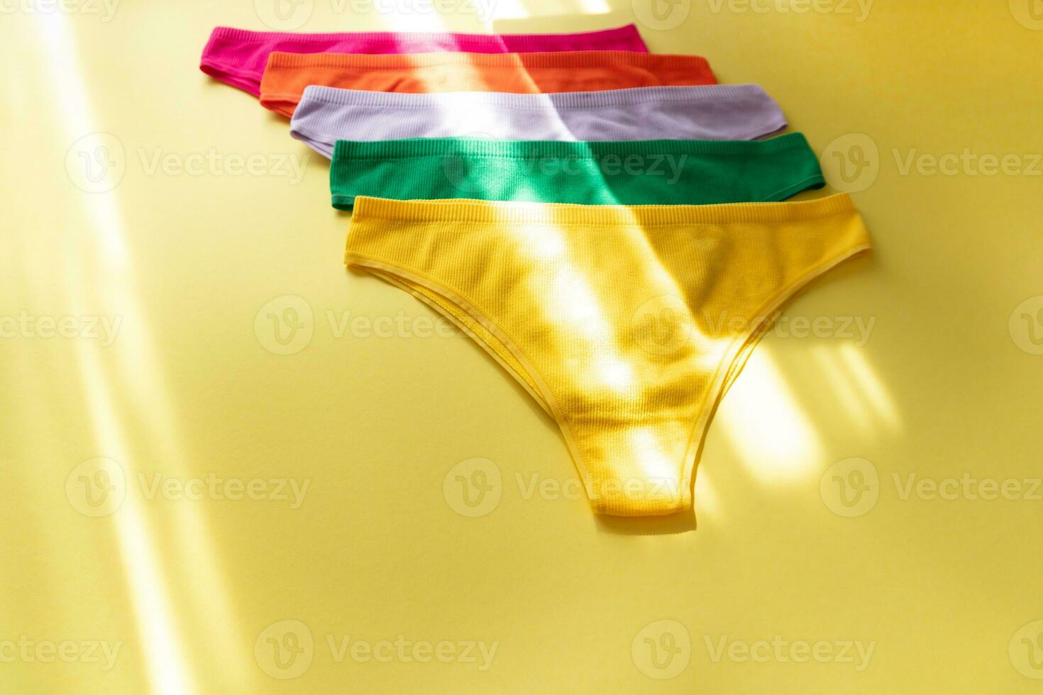 Set of colorful underpants on yellow background, close up photo