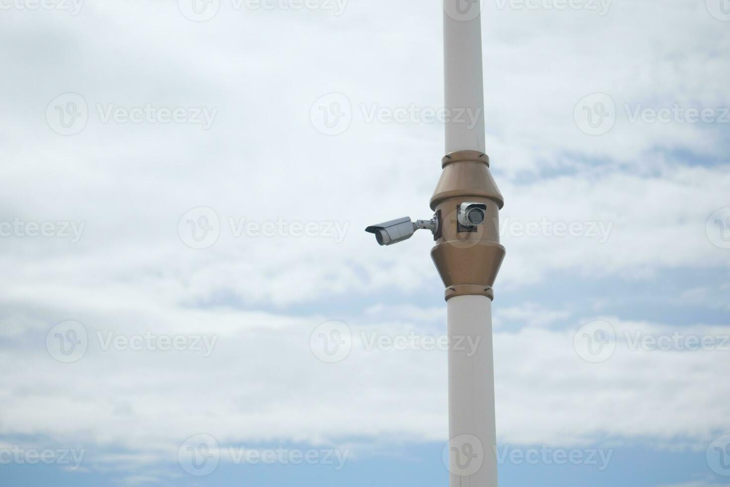 CCTV security camera operating against blue sky with copy space photo