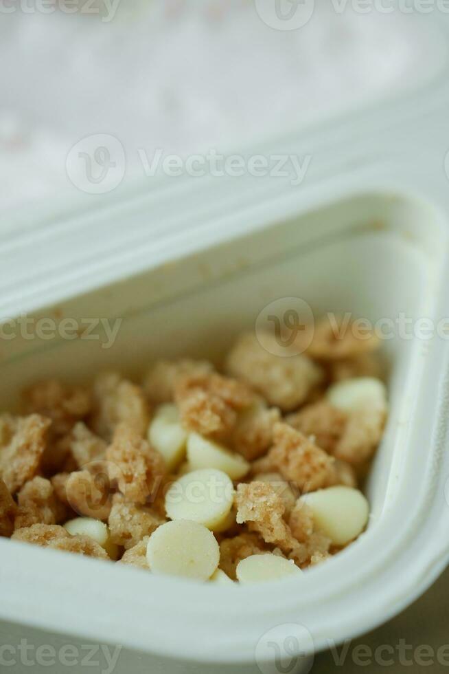 fresh yogurt in a plastic container and spoon on table photo