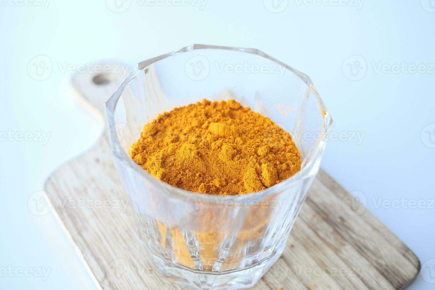 turmeric root powder in a jar on table photo