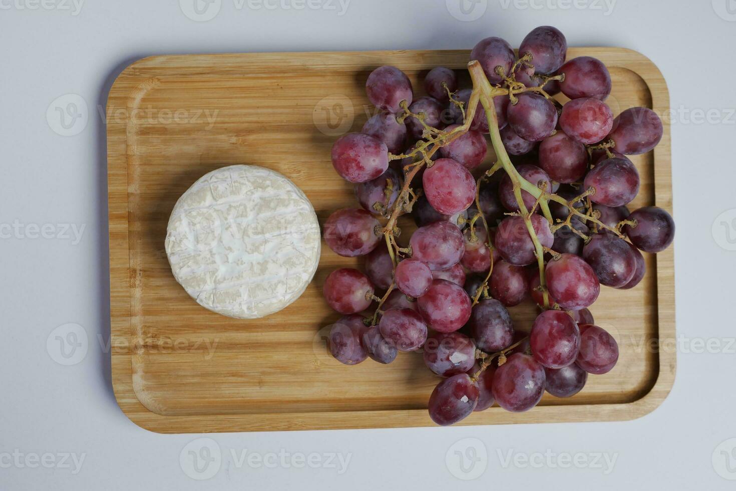 Camembert cheese and grape fruit on table photo