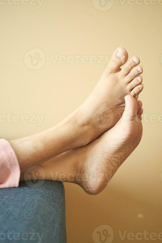 relax women feet lying on sofa in a bright house photo