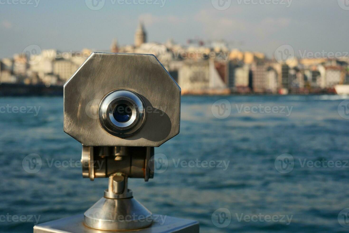 Coin-operated binoculars looking out over city , photo