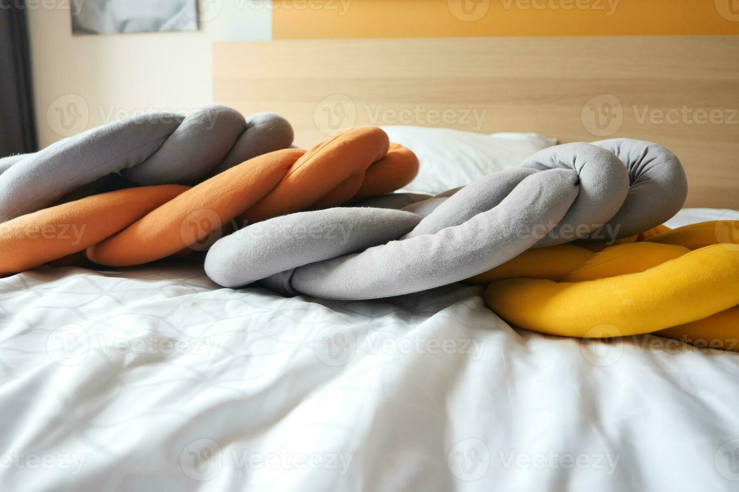 gray, orange and yellow pillows on bed photo