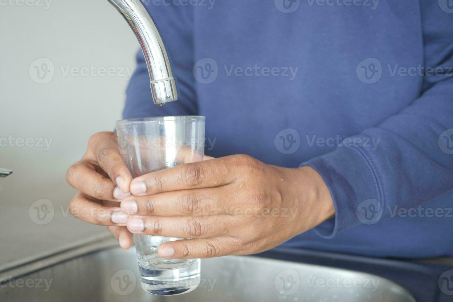 dirty water pouring from a faucet tap in a glass, photo